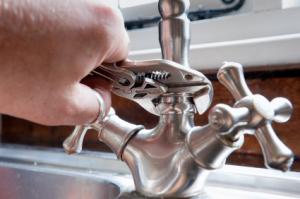 Tracy handyman tightens a sink faucet
